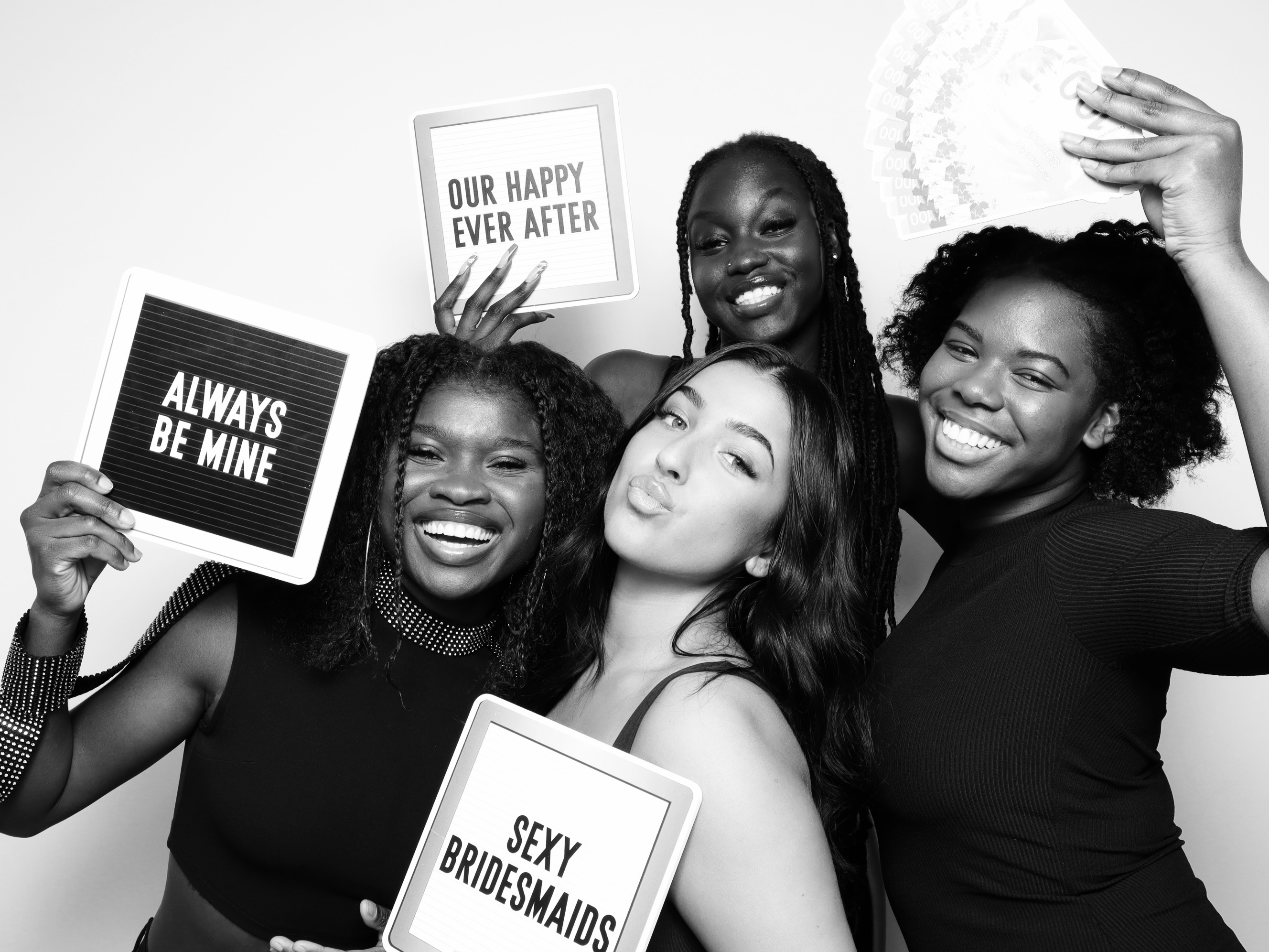 Four women posing with props at the Onyx Glam Booth