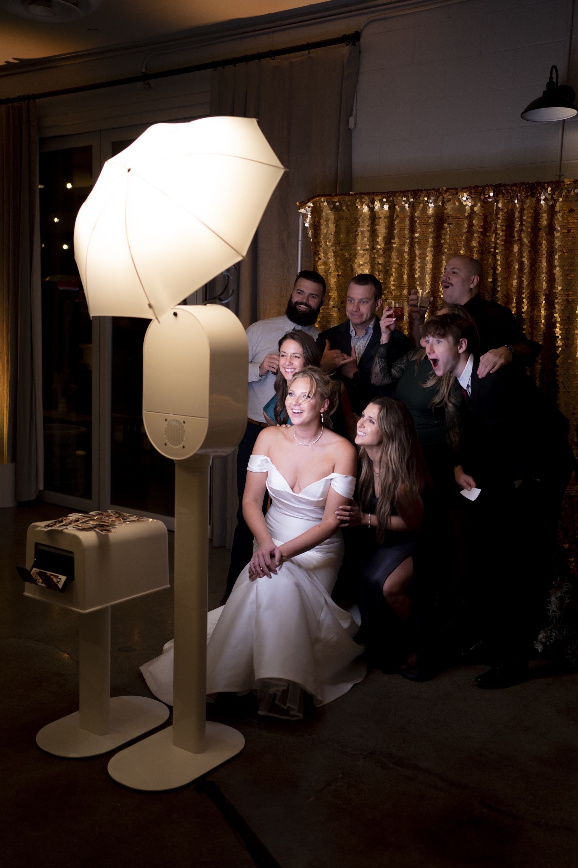 Wedding guests gathered around Onyx Photo Booth at night reception