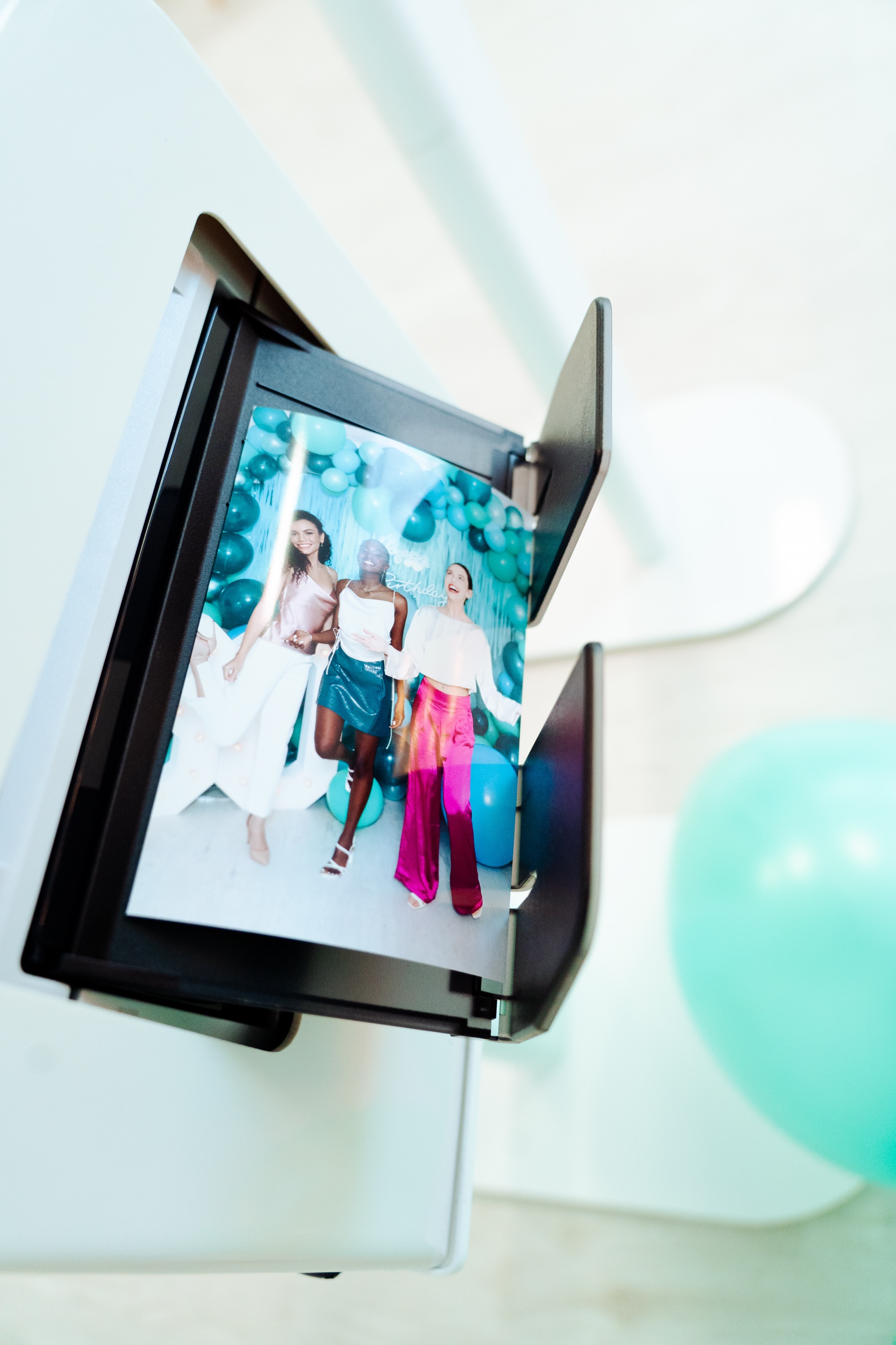 Photo print coming out of the booth printer showing guests posing